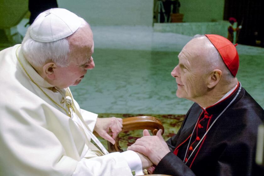 FILE - In this Feb. 23, 2001 file photo, U.S. Cardinal Theodore Edgar McCarrick, archbishop of Washington, D.C., shakes hands with Pope John Paul II during the General Audience with the newly appointed cardinals in the Paul VI hall at the Vatican. McCarrick was one of the three Americans on a record list of 44 new cardinals who were elevated in a ceremony at the Vatican on Feb. 21, 2001. (AP Photo/Massimo Sambucetti, File)