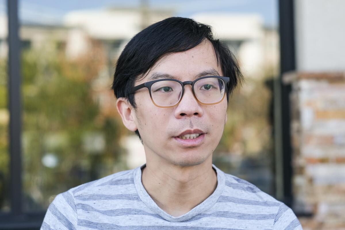 A head-and-shoulders portrait of Johnny Lin, a young Asian man wearing glasses and a striped shirt.