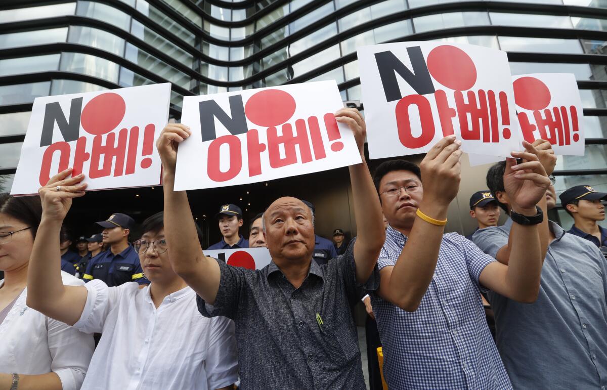 South Korean protesters hold up signs reading "No Abe" during a rally against Japan in front of the Japanese Embassy in Seoul on Friday.