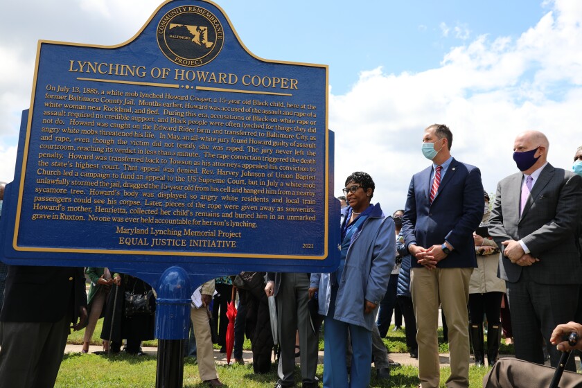 Maryland Gov. Larry Hogan, far right, Baltimore County Executive John Olszewski and Maryland House Speaker Adrienne Jones stand next to a new historic marker on Saturday, May 8, 2021 in Towson, Md., that memorializes Howard Cooper, a 15-year-old who was dragged from a jailhouse and hanged from a tree by a mob of white men in 1885. Hogan signed a posthumous pardon for 34 men, including Cooper, who were lynched in the state between 1854 and 1933 without due process against allegations they faced. (AP Photo/Brian Witte)