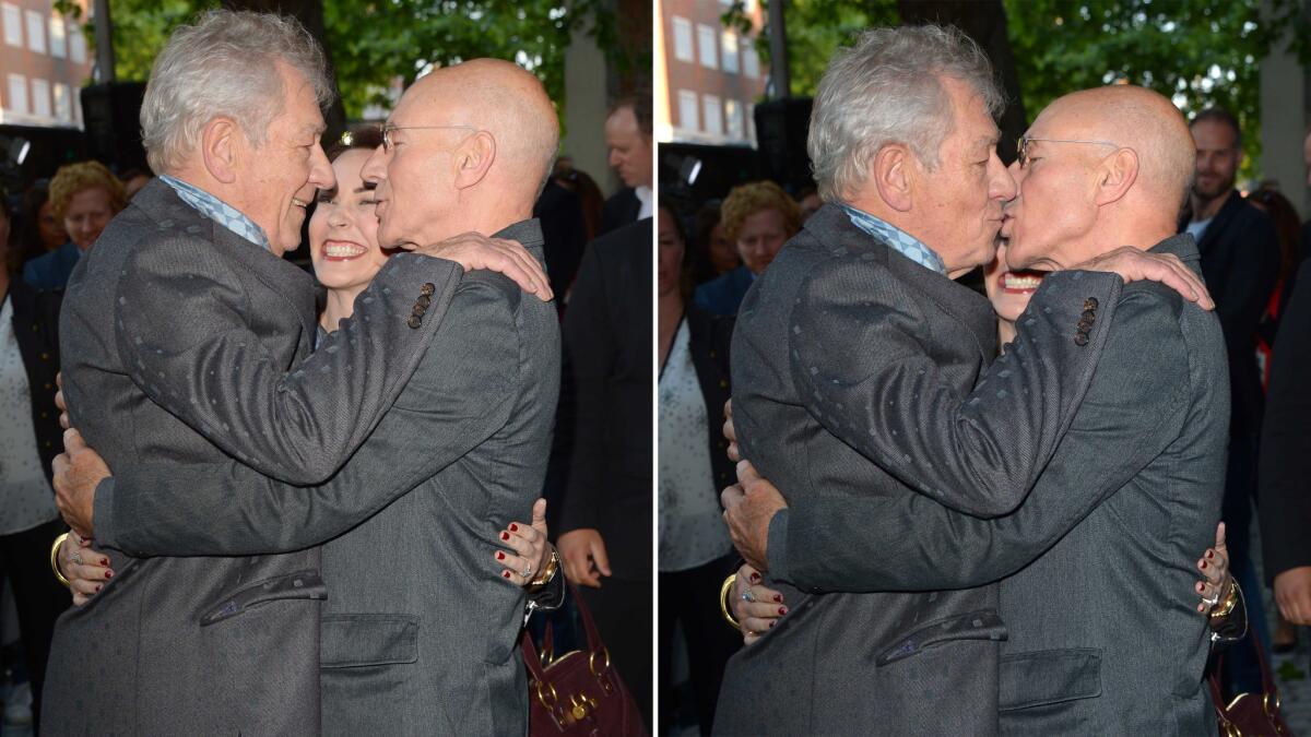 Actors Ian McKellen, left, and Patrick Stewart kiss at the U.K. premiere of "Mr. Holmes" in Kensington as Sunny Ozell, Stewart's wife, watches.