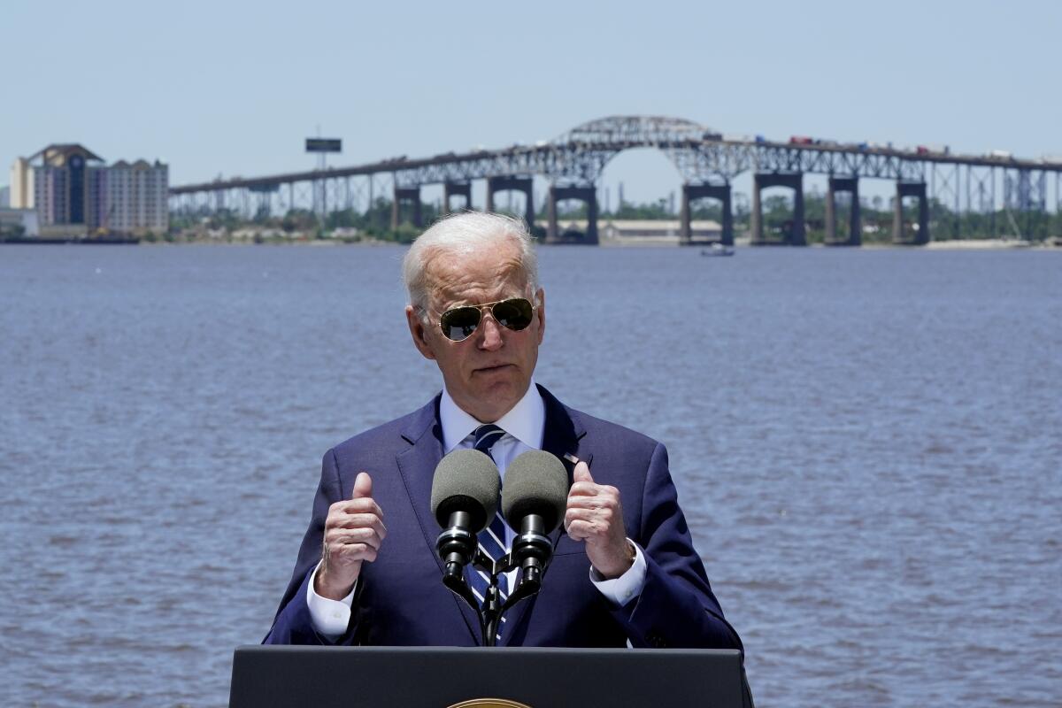 President Biden speaks with the Interstate 10 Calcasieu River Bridge behind him on Thursday in Lake Charles, La. 