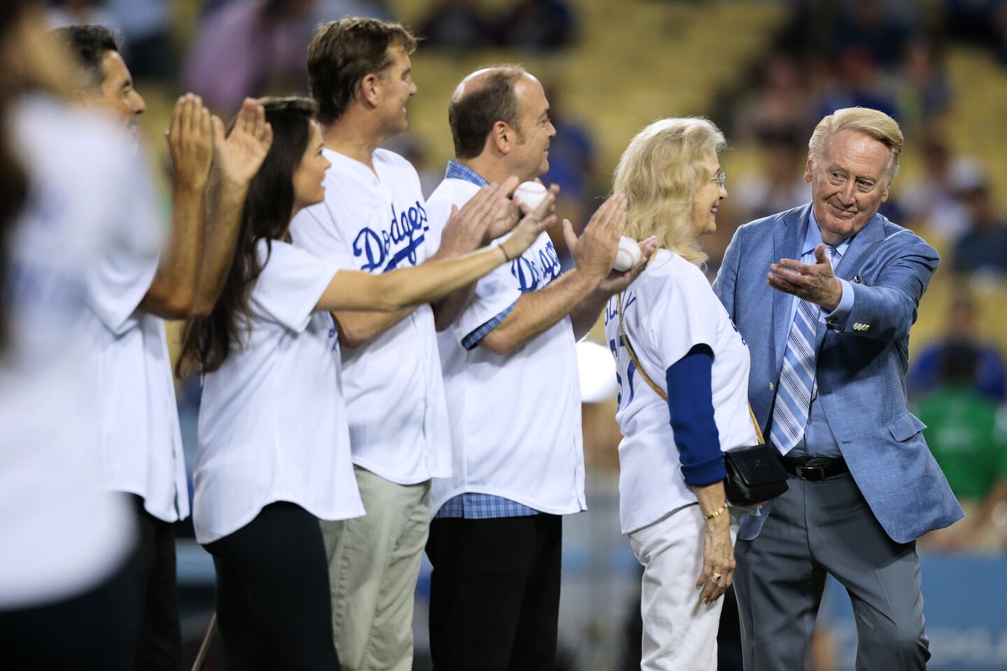 Vin Scully is applauded on the field at Dodger Stadium, by family members, as he is recognized by the Guiness Book of World Records as the "longest tenured sports team employee" on September 23, 2015.