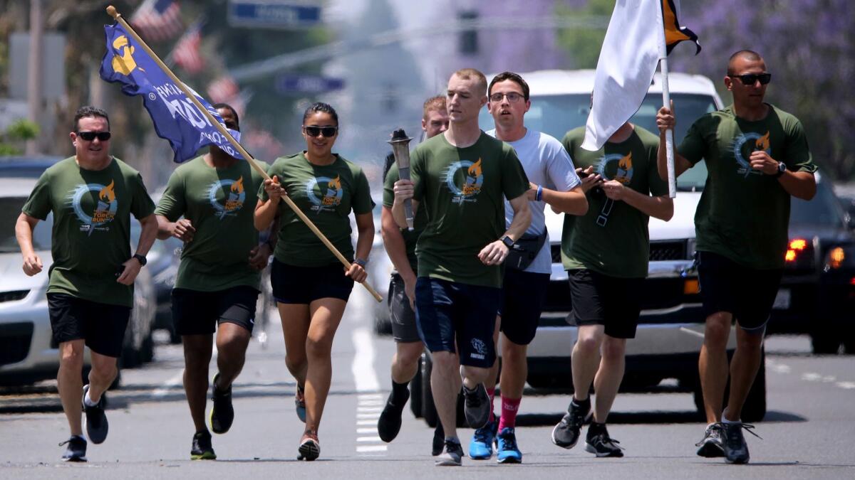 Glendale police officers carry the torch on Glenoaks Boulevard during the Special Olympics Torch run in Glendale on Wednesday, June 5, 2019.