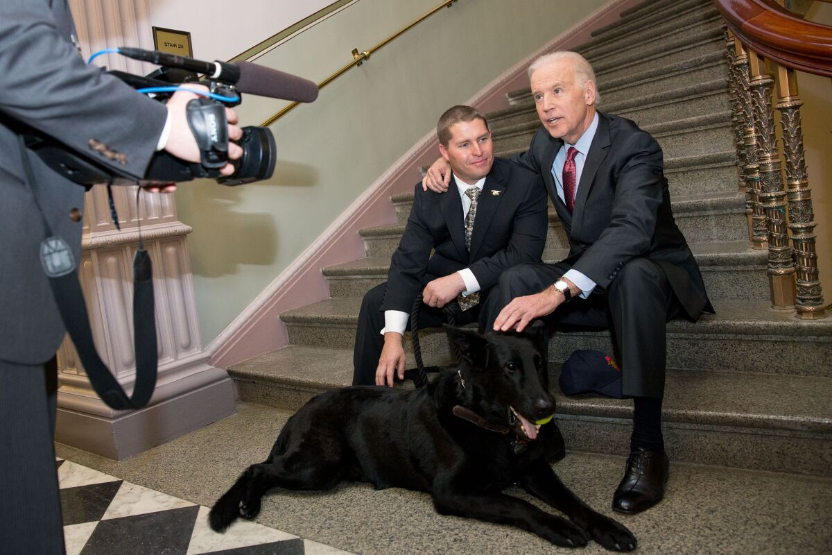 Then-Vice President Joe Biden met with SEAL dog “Chopper” and his handler, Trevor Maroshek, a Navy SEAL Veteran, in the Eisenhower Executive Office Building, April 8, 2014.