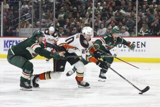 Anaheim Ducks right wing Brett Leason (20) advances the puck against Minnesota Wild defensemen.