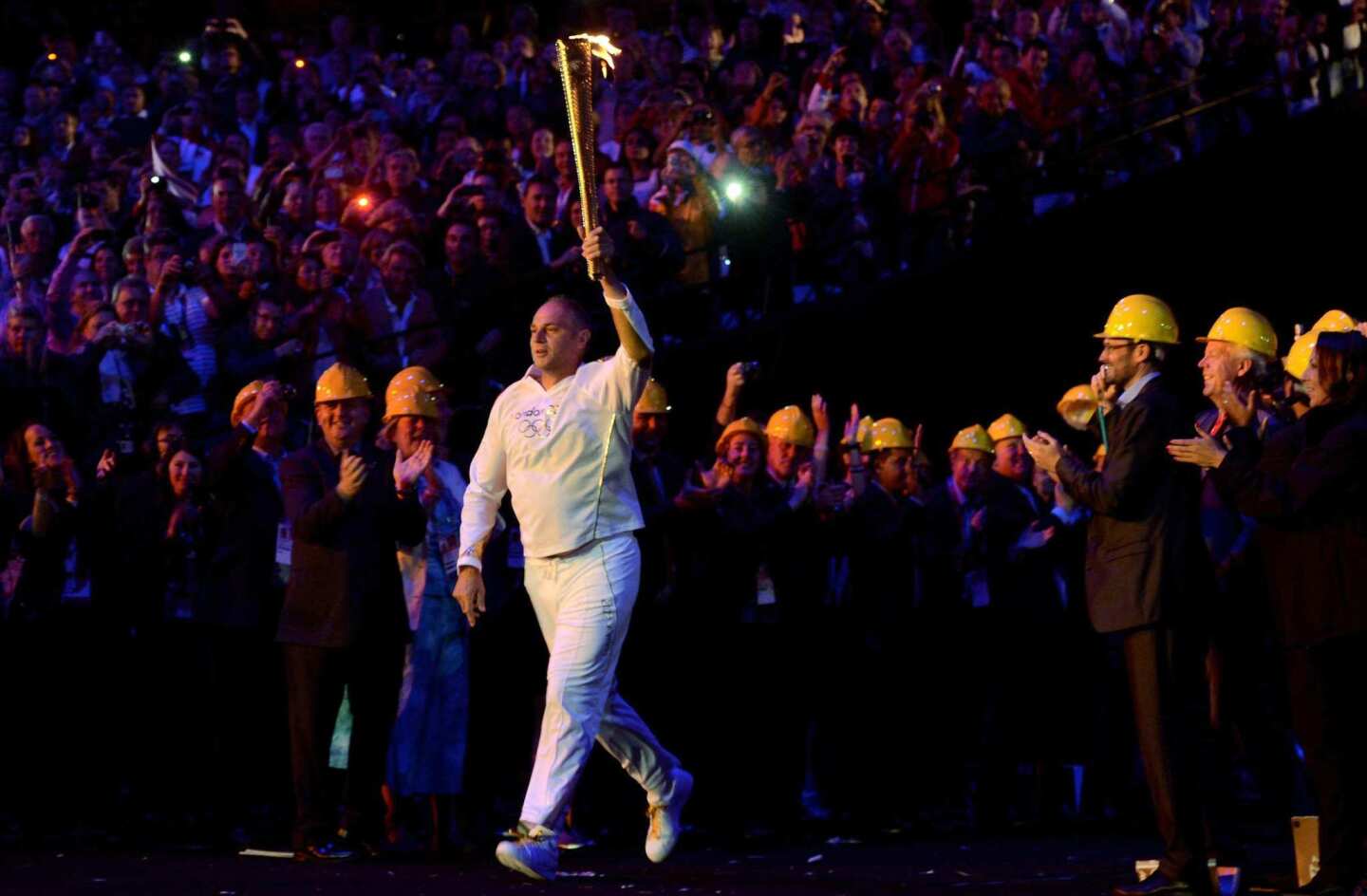 Sir Steve Redgrave, a former British rower who won five Olympic gold medals from 1984 to 2000, carries the torch into London's Olympic Stadium during the opening ceremony on Friday.