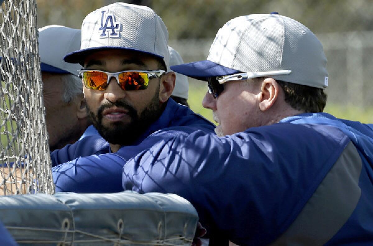 Dodgers center fielder Matt Kemp, left, talks with hitting coach Mark McGwire during a workout at spring training last month.