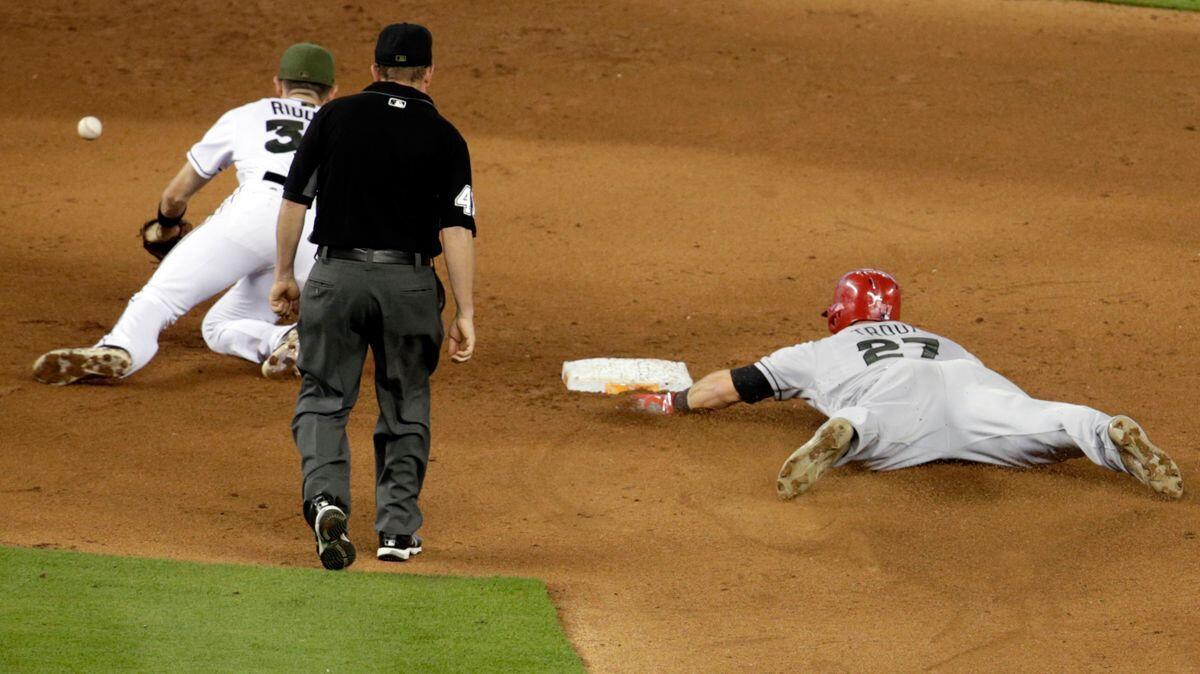 The Angels' Mike Trout (27) steals second base as the ball gets away from Miami Marlins shortstop J.T. Riddle during the fifth inning on May 28. Trout injured his left thumb on the play.