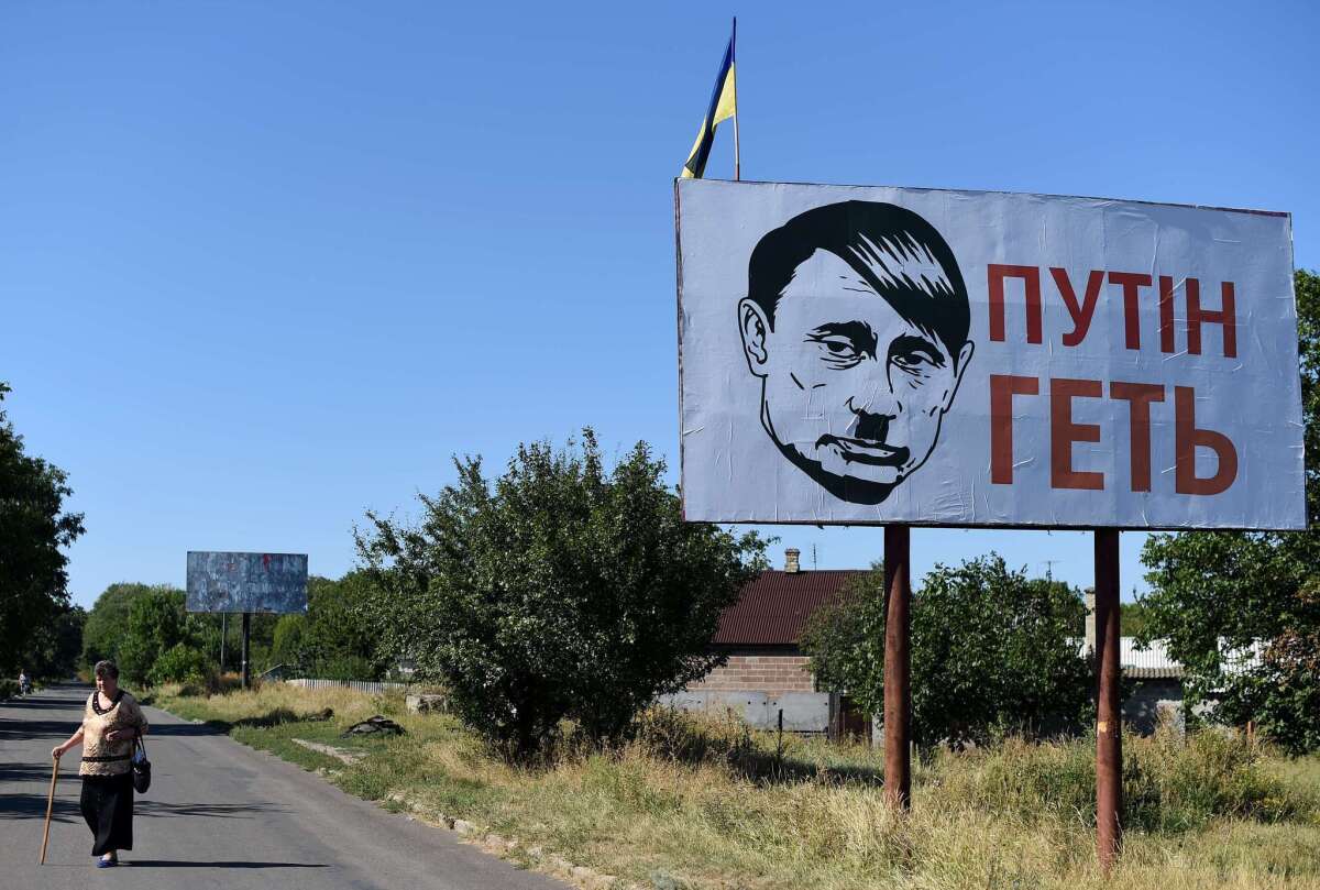 A billboard in the eastern Ukraine town of Volnovakha depicts Russian President Vladimir Putin with a Hitler mustache and haircut.