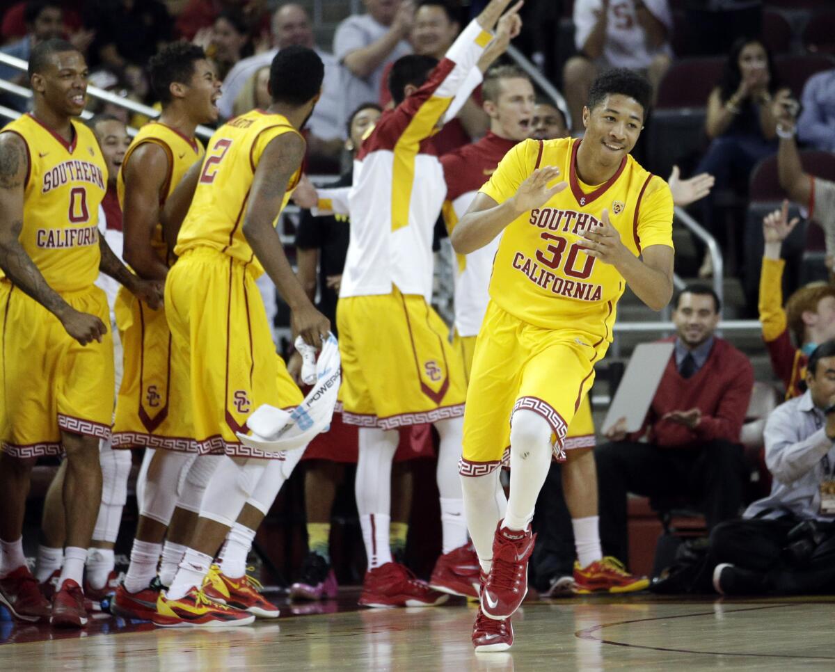 USC forward Elijah Steward (30) as well as teammates on the bench celebrate after a basket in the second half of a 68-55 victory over Oregon State on Saturday at the Galen Center.