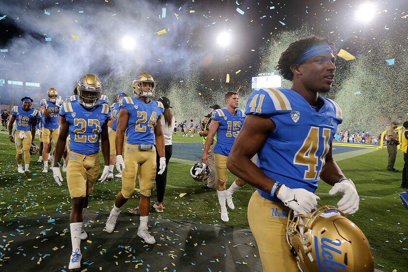 PASADENA, CALIF. - SEP. 4, 2021. The UCLA Bruins football team leaves the field under a hail of confetti after beating LSU, 38-27, at the Rose Bowl on Saturday, Sept. 4, 2021. (Luis Sinco / Los Angeles Times)