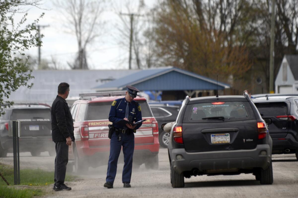 Police stand outside Swan Creek Boat Club in Michigan after a crash.