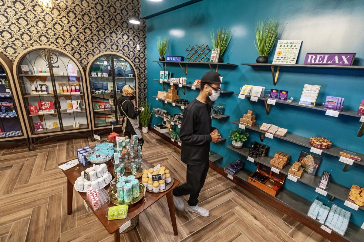 The speakeasy-themed interior of a dispensary with two people shopping