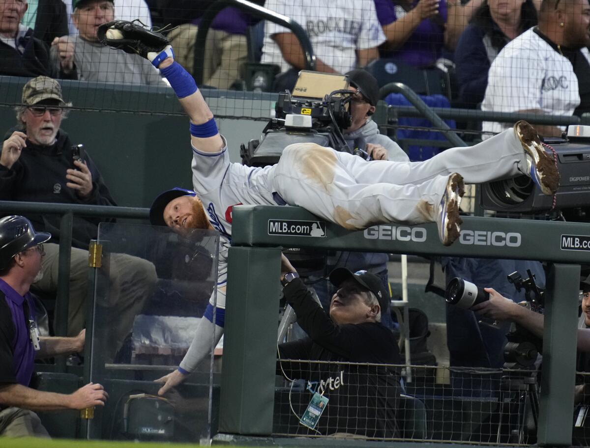 Dodgers third baseman Justin Turner tumbles over the rail and into the third-base photo well.