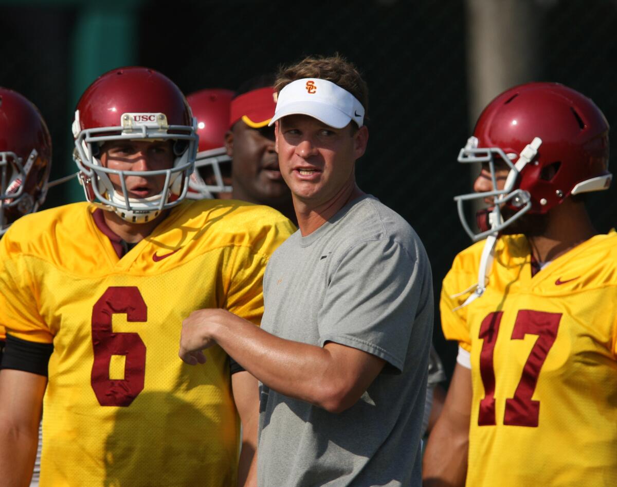 Then-USC Coach Lane Kiffin talks to quarterback Cody Kessler on Aug. 17, 2012.