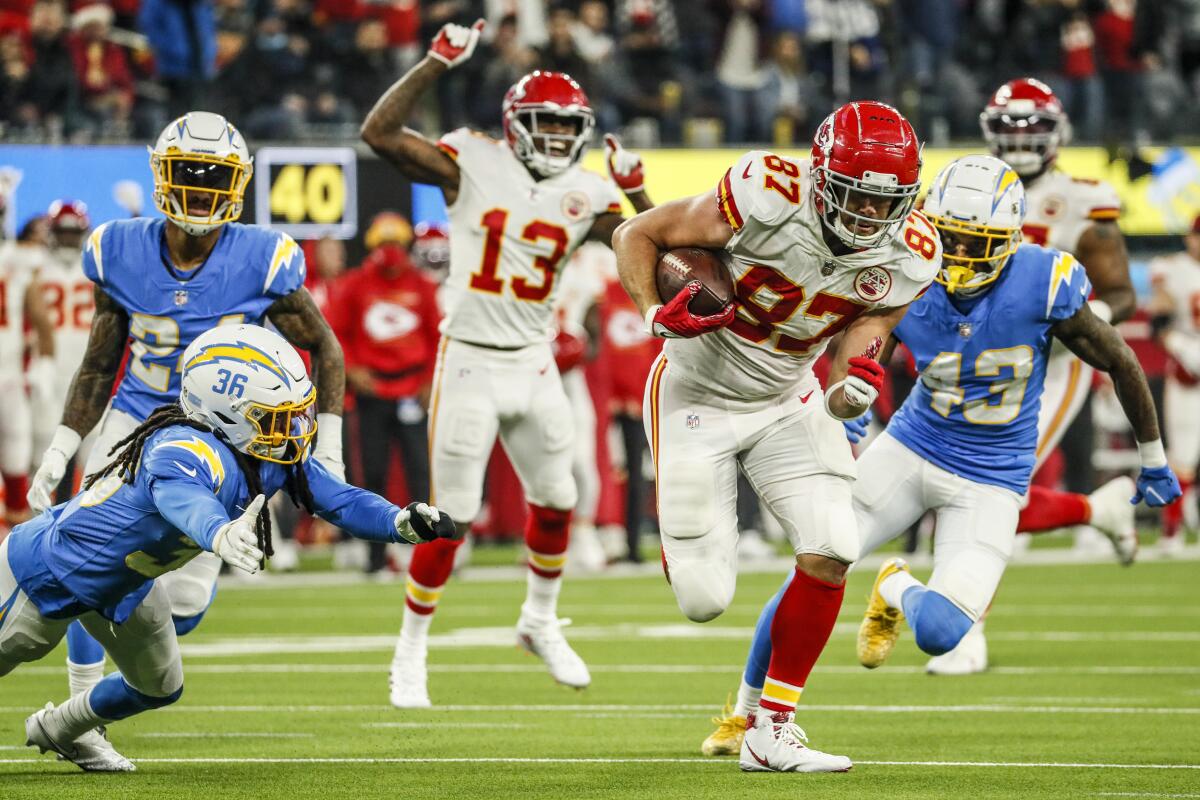 Chiefs tight end Travis Kelce weaves his way past Chargers defensive back Trey Marshall and cornerback Michael Davis.