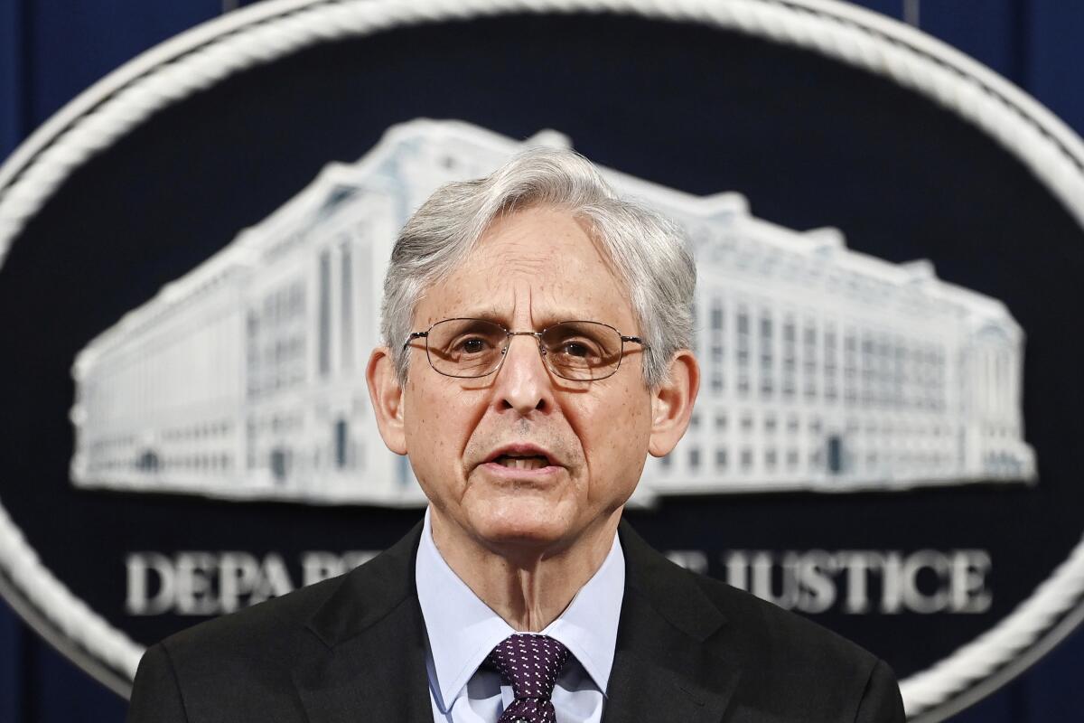 Atty. Gen. Merrick Garland speaks in front of a Department of Justice sign