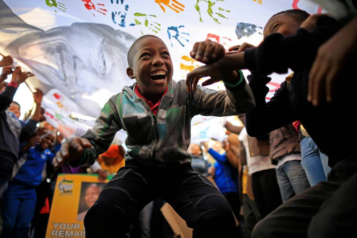 A boy joins in the Nelson Mandela birthday celebrations outside the Pretoria hospital where the former president is being treated.