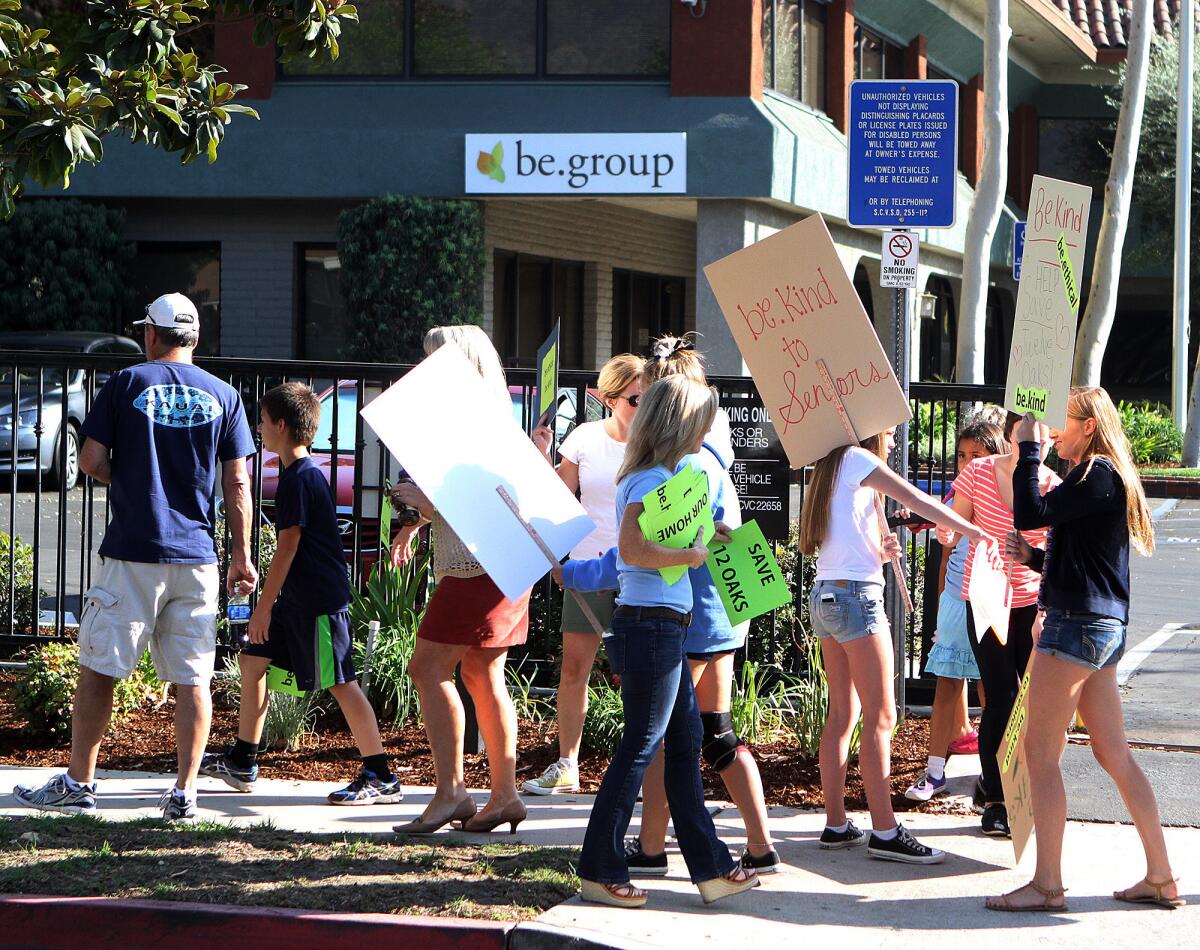 Protesters gather and begin to walk in protest in front of be.group in Glendale, protesting the closing of 12 Oaks Lodge in La Crescenta on Wednesday, October 2, 2013. Nearly 125 people protested in front of the Glendale business.