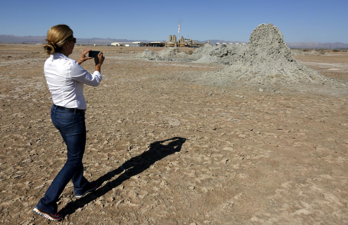 Attorney Maria C. Severson, whose firm has represented the Imperial Irrigation District on energy matters, snaps a picture of the mud mounds formed by the geothermal energy beneath the surface near the Salton Sea in Southern California's Imperial Valley.
