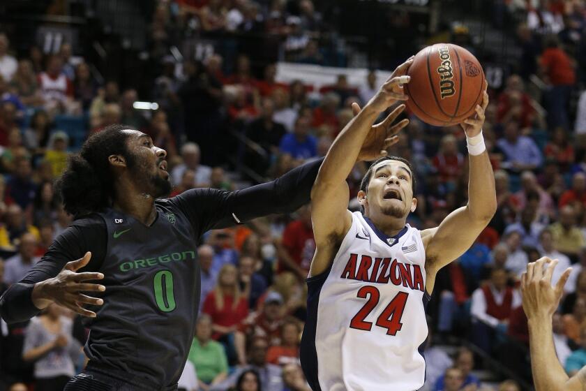 Arizona's Elliott Pitts, right, grabs a rebound over Oregon's Dwayne Benjamin during the Pac-12 championship game Saturday in Las Vegas.