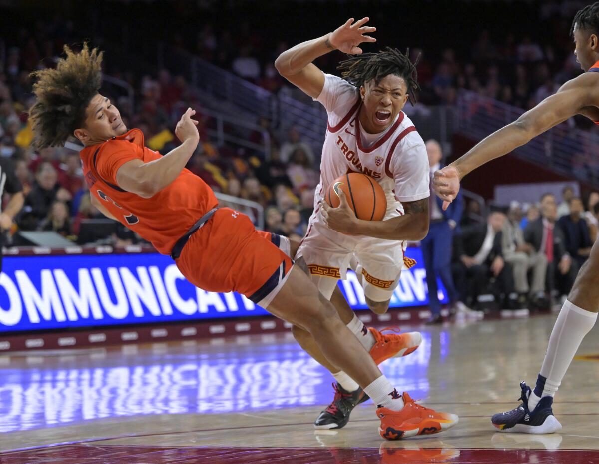 USC guard Boogie Ellis is fouled by Auburn guard Tre Donaldson while driving to the basket.
