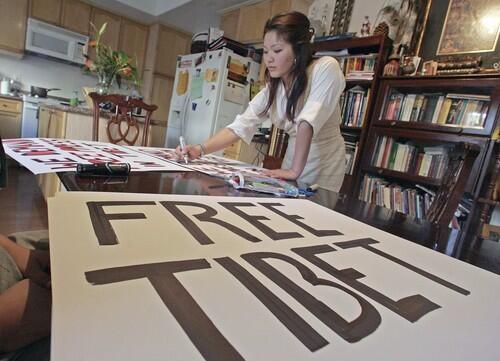 Norzin Khangtetsang makes signs for a protest against Chinese rule in Tibet.