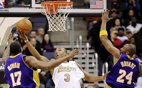 Wizards forward Caron Butler, donning a Chicago Zephyrs uniform that the franchise wore before moving to Washington, goes for a reverse layup against Lakers center Andrew Bynum and guard Kobe Bryant in the first half Friday.