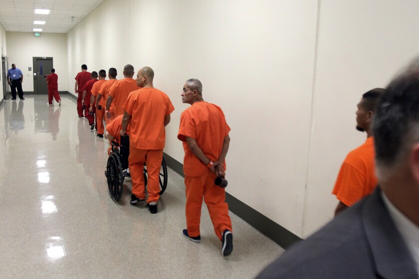 Immigration detainees walk in one of the hallways of a detention facility in Adelanto, Calif.