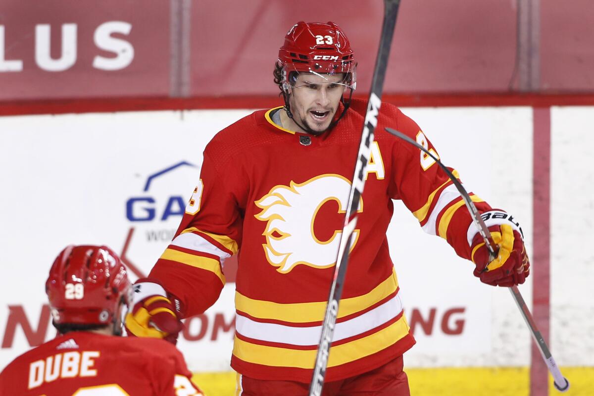 Calgary Flames' Sean Monahan, right, celebrates his goal against the Edmonton Oilers with Dillon Dube during the second period of an NHL hockey game Saturday, April 10, 2021, in Calgary, Alberta. (Larry MacDougal/The Canadian Press via AP)