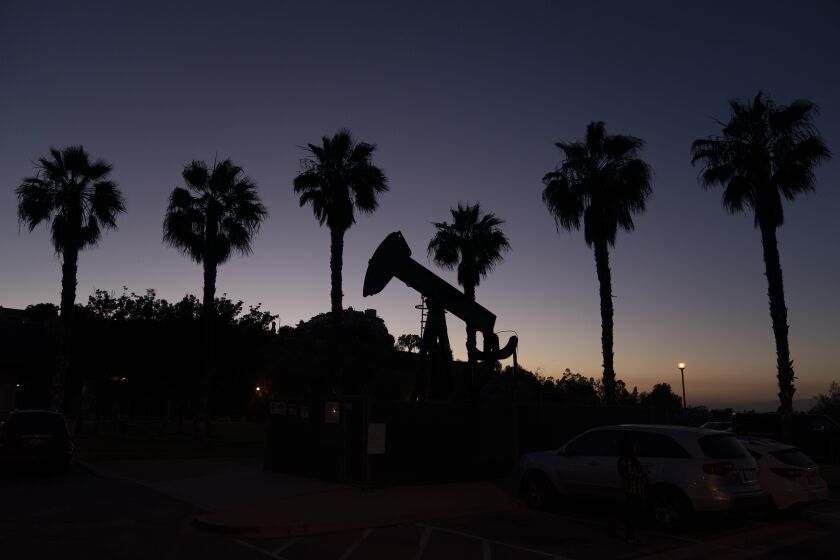FILE - A pump jack sits idle in front of palm trees on June 9, 2021, in Signal Hill, Calif. California Gov. Gavin Newsom on Tuesday, March 28, 2023, is scheduled to sign a new law that would let regulators decide whether to penalize oil companies for making too much money from price spikes at the pump. (AP Photo/Jae C. Hong, File)