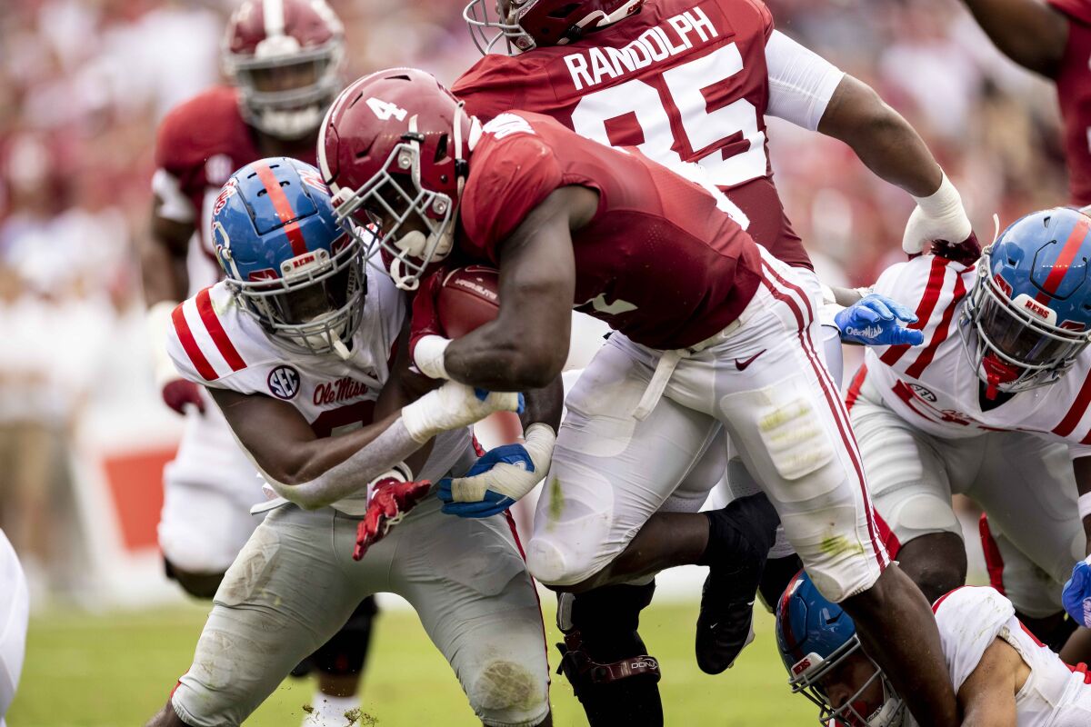 Alabama running back Brian Robinson Jr. (4) runs by Mississippi linebacker Lakia Henry (0) during the first half of an NCAA college football game, Saturday, Oct. 2, 2021, in Tuscaloosa, Ala. (AP Photo/Vasha Hunt)