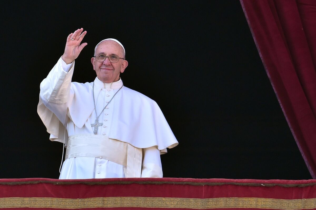 Pope Francis waves from the balcony of St. Peter's basilica during the traditional "Urbi et Orbi" Christmas Day message at St. Peter's square in the Vatican.