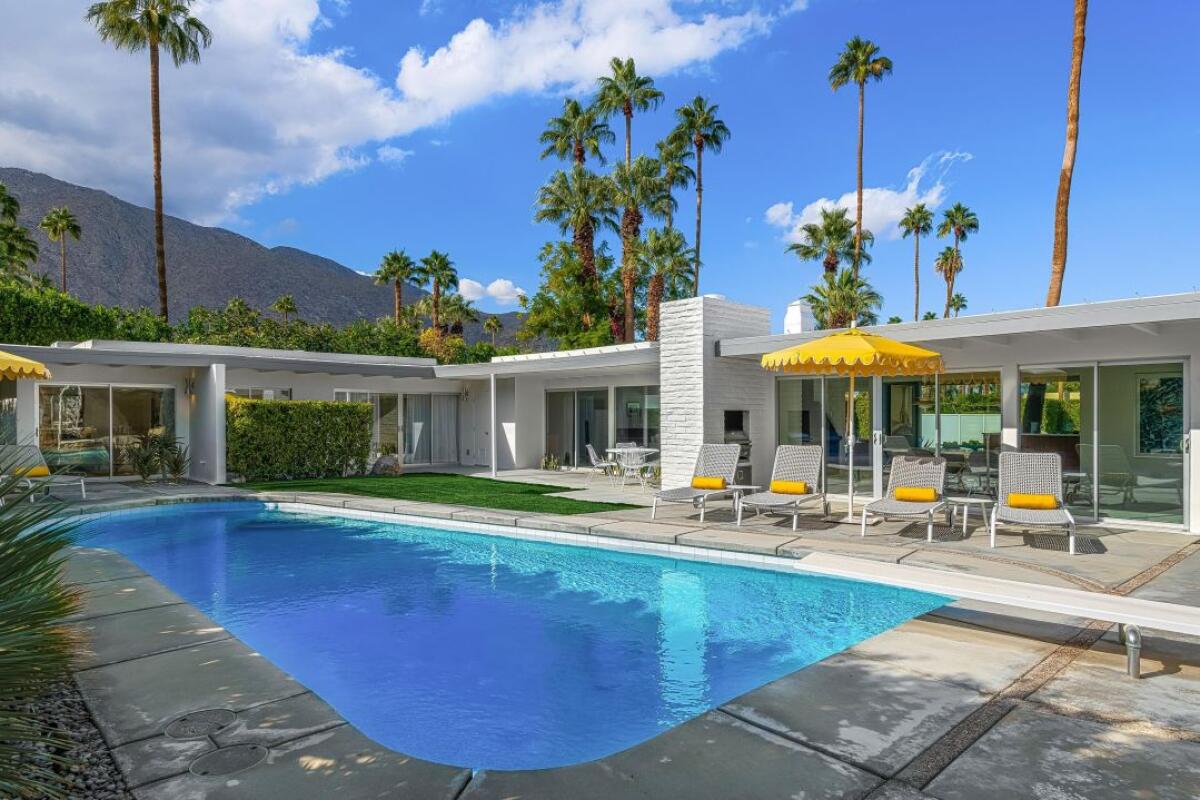 A swimming pool outside a low-slung Midcentury house in Palm Springs.