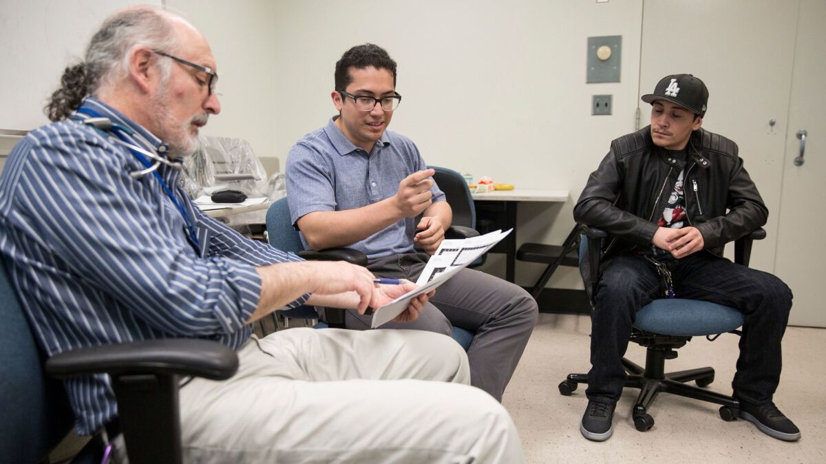 Dr. Marc Weigensberg, left, leads a group session with Type 1 diabetes patients Fabio Lara, 21, center, and Gabriel Leon, 26, at Los Angeles County-USC Medical Center.