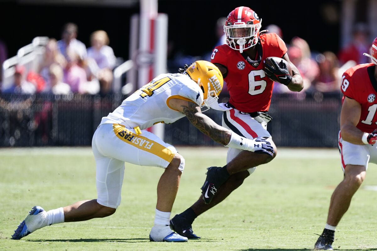 Georgia running back Kenny McIntosh (6) is stopped by Kent State linebacker Rocco Nicholl (44) in the first half of an NCAA college football game Saturday, Sept. 24, 2022, in Athens, Ga. (AP Photo/John Bazemore)