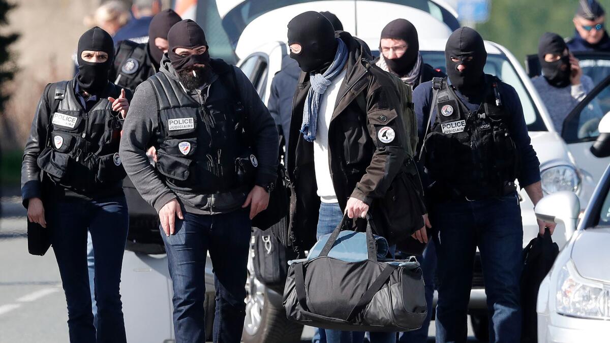 Masked police officers are seen after their assault on the Super U supermarket where a gunman claiming allegiance to the Islamic State was holding hostages in Trebes, southern France, 23 March 2018.
