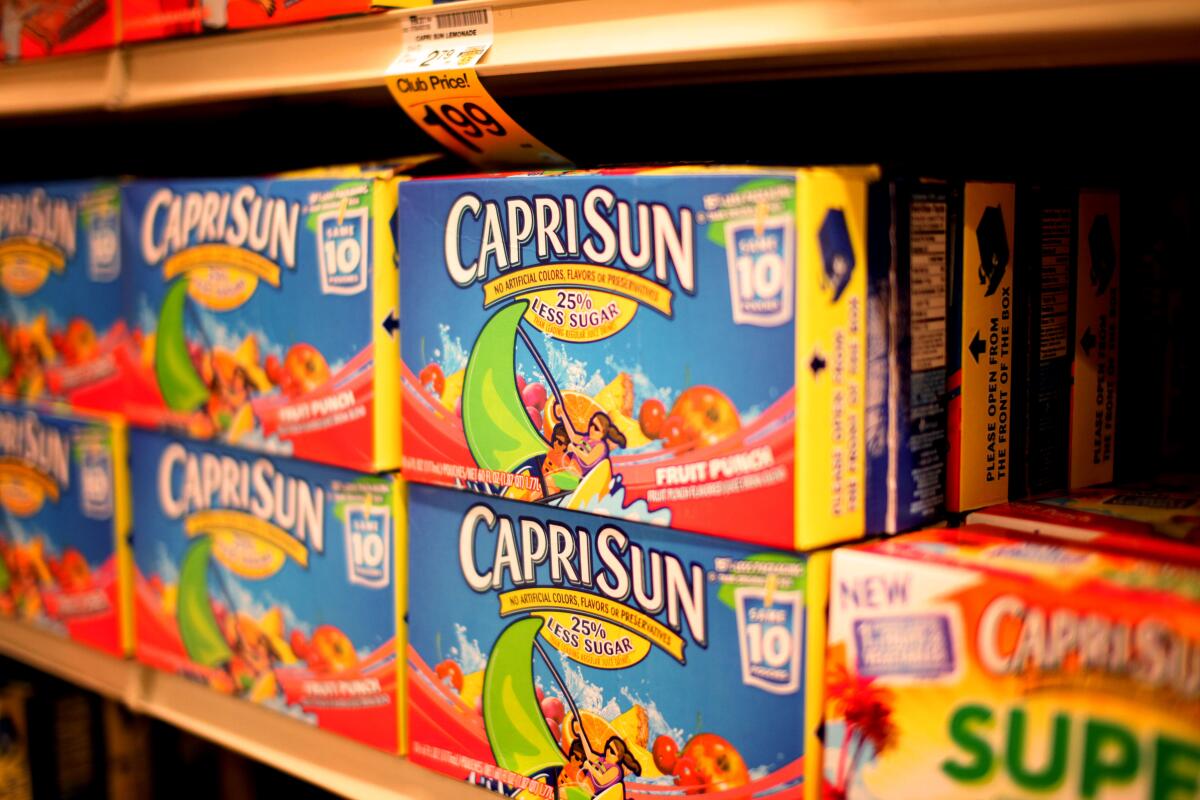Boxes of Capri Sun juice sit on a grocery store shelf.