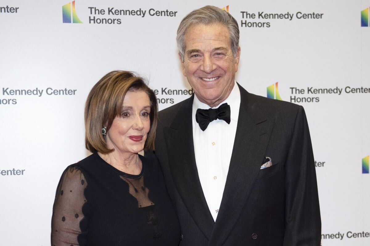 Nancy Pelosi and husband Paul Pelosi standing in front of a backdrop reading "The Kennedy Center Honors"