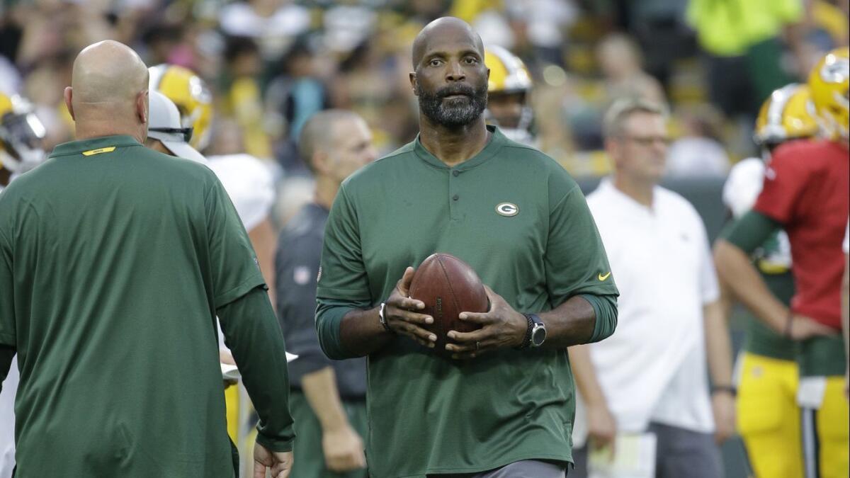 Winston Moss, then the Packers' associate head coach, walks on the sideline during a night practice at Lambeau Field in August.