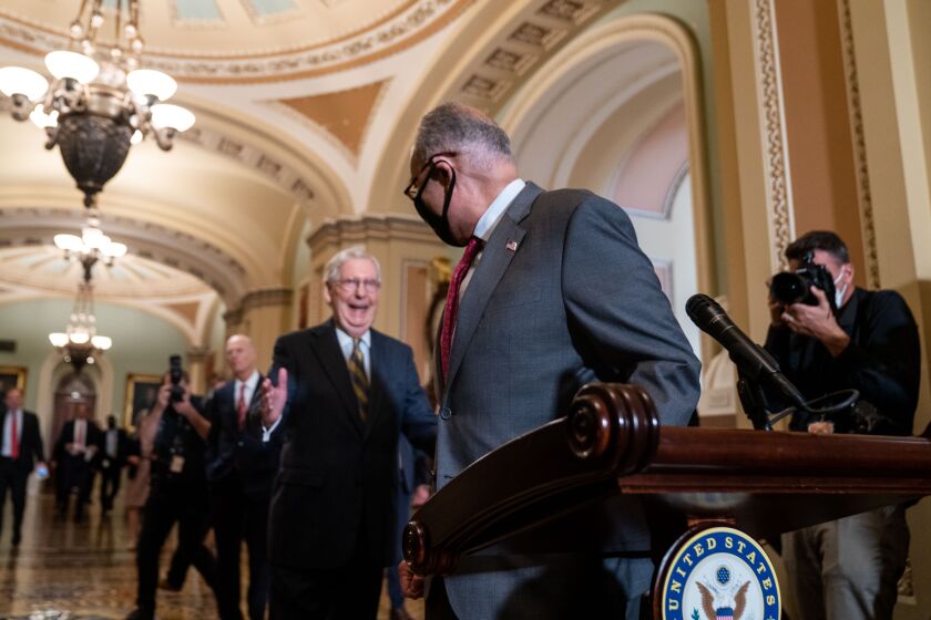 WASHINGTON, DC - AUGUST 03: Senate Majority Leader Chuck Schumer (D-NY) races to the podium against Senate Minority Leader Mitch McConnell (D-KY) in the Ohio Clock Corridor on Capitol Hill on Tuesday, Aug. 3, 2021 in Washington, DC. (Kent Nishimura / Los Angeles Times)