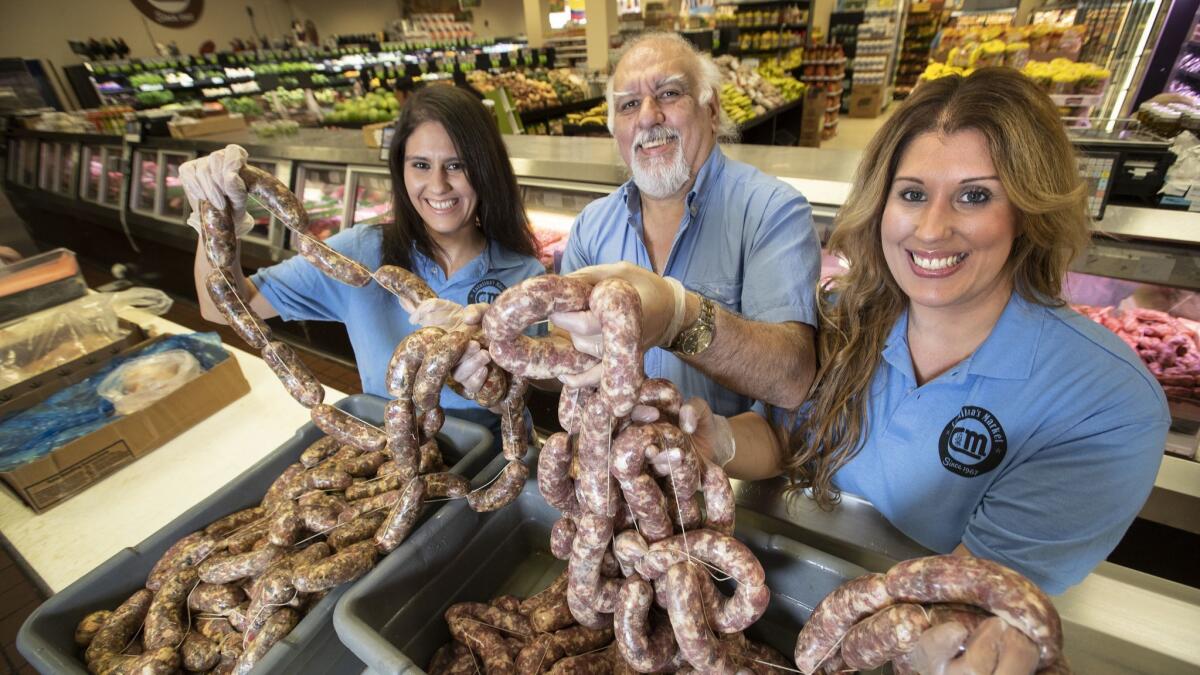 Felipe Corrado Jr., center, and daughters Natalie, left, and Diana handle the signature sausages at their Argentine butcher shop and grocery store.