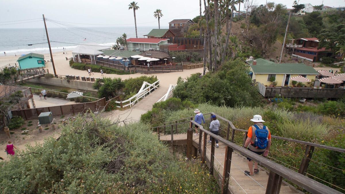 Beach-goers arrive at Crystal Cove. The Crystal Cove Conservancy partners with the state Department of Parks and Recreation to preserve nearly 2,800 acres of public land.