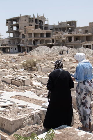 A girl and her mother visit the grave