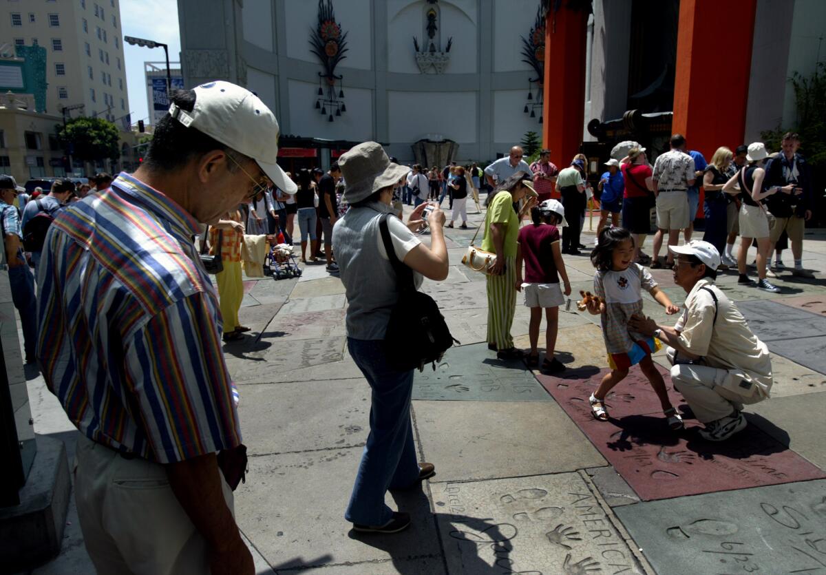 Tourists swarm the Chinese Theatre in Hollywood on June 24, 2004.
