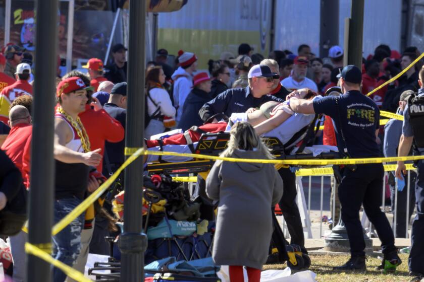 A woman is taken to an ambulance after an incident following the Kansas City Chiefs NFL football Super Bowl celebration in Kansas City, Mo., Wednesday, Feb. 14, 2024. The Chiefs defeated the San Francisco 49ers Sunday in the Super Bowl 58. (AP Photo/Reed Hoffmann)
