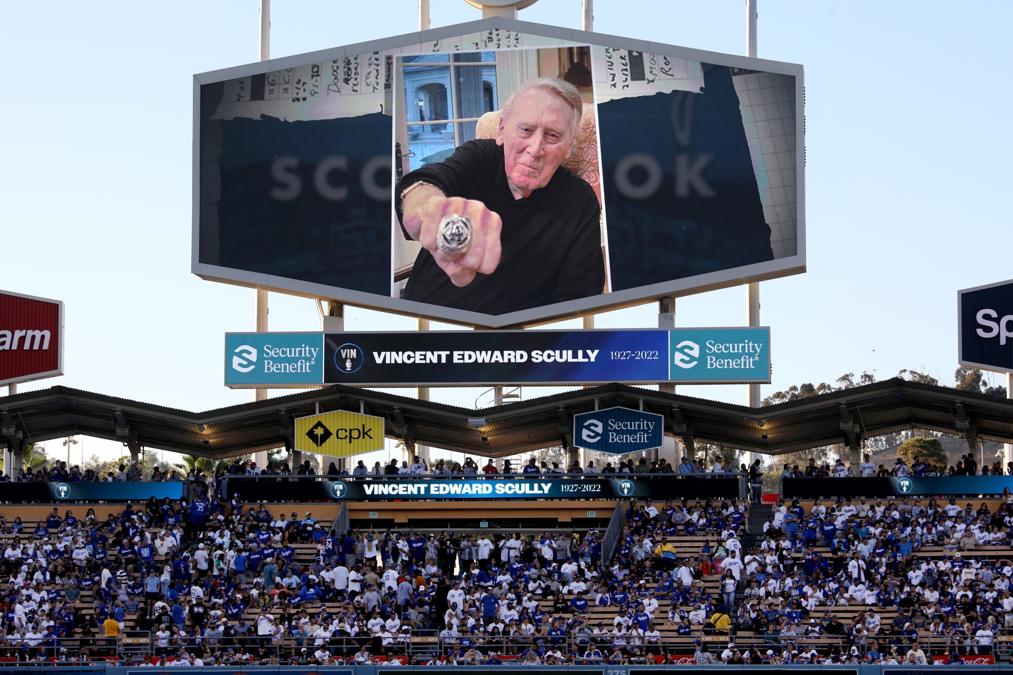 शुक्रवार के प्रीगेम समारोह के दौरान डोजर स्टेडियम में बड़े पर्दे पर विन स्कली की एक तस्वीर प्रदर्शित की गई है।