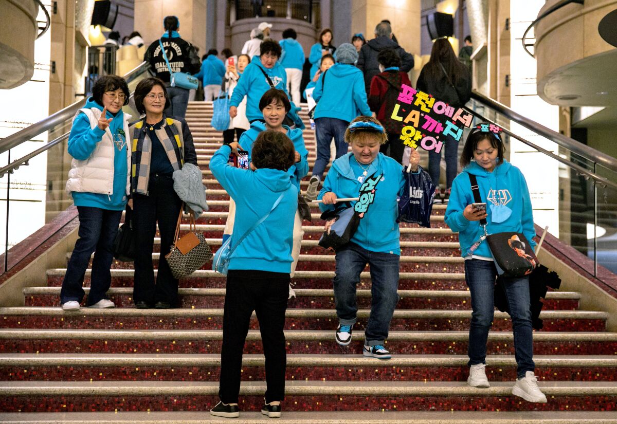 Sekelompok orang, mengenakan kaus biru muda, menuruni tangga lebar. 