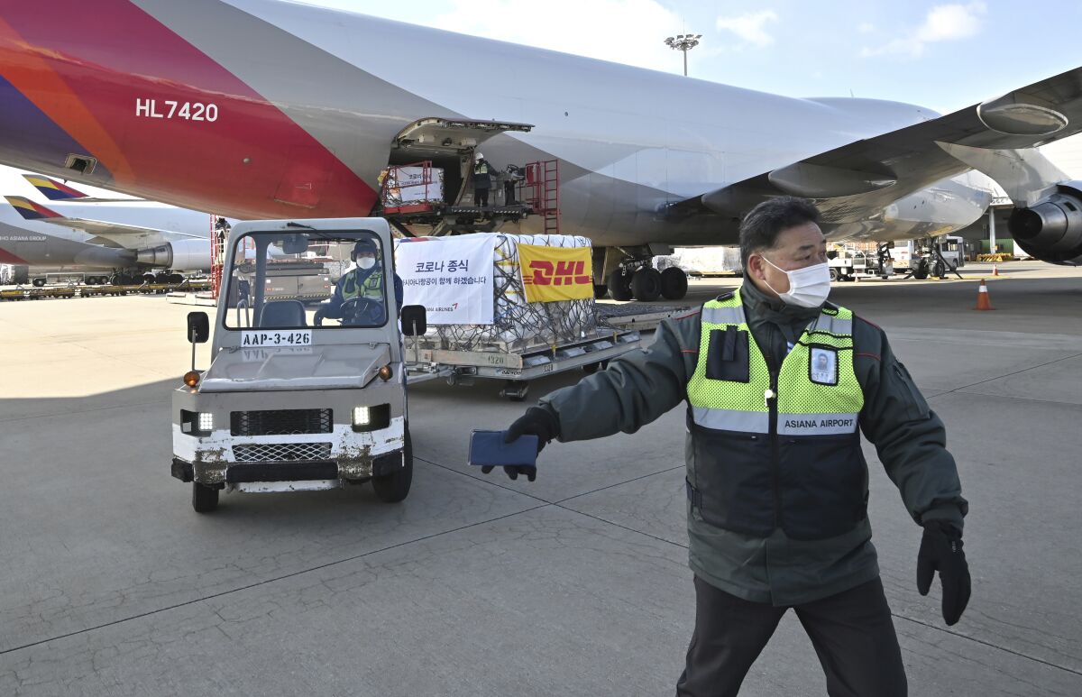 Workers transport a cargo shipment containing the first batches of Pfizer's antiviral COVID-19 pill, Paxlovid, at a cargo terminal at the Incheon International Airport, west of Seoul, South Korea, on Thursday, Jan. 13, 2022. Jung Yeon-je/Pool photo via AP)